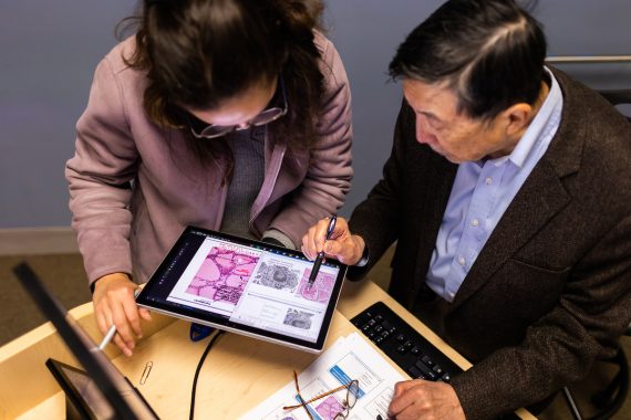 A student and professor are working together, looking at medical images on a tablet, at Tufts' Graduate School of Biomedical Sciences on the Boston campus.