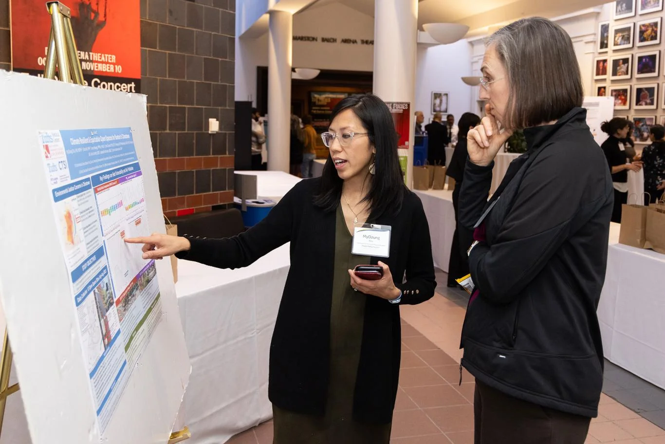 Part of the summit: a midday poster session. Here, MyDzung Chu, assistant professor in the Departments of Medicine and Public Health and Community Medicine at the School of Medicine, shares a finding with Tina Woolston, director of Tufts' Office of Sustainability.