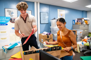 Luke Fredericks works with Evelyn Pedroza, Jumpstart site manager, at Tisch College at Barnum Hall on August 7, 2023. Fredericks is a Boston high school student who interned at Tufts as part of the Boston Summer Youth Employment Program.